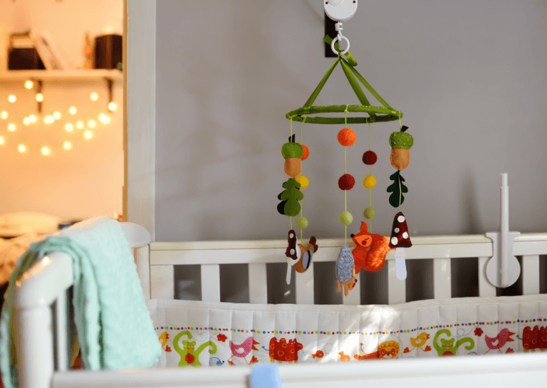 Colorful baby mobile with spinning toys hanging above a crib, creating a cheerful atmosphere for the nursery.