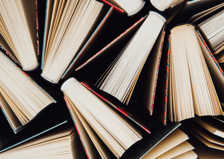 Several books standing upright, filmed from above on a black background.