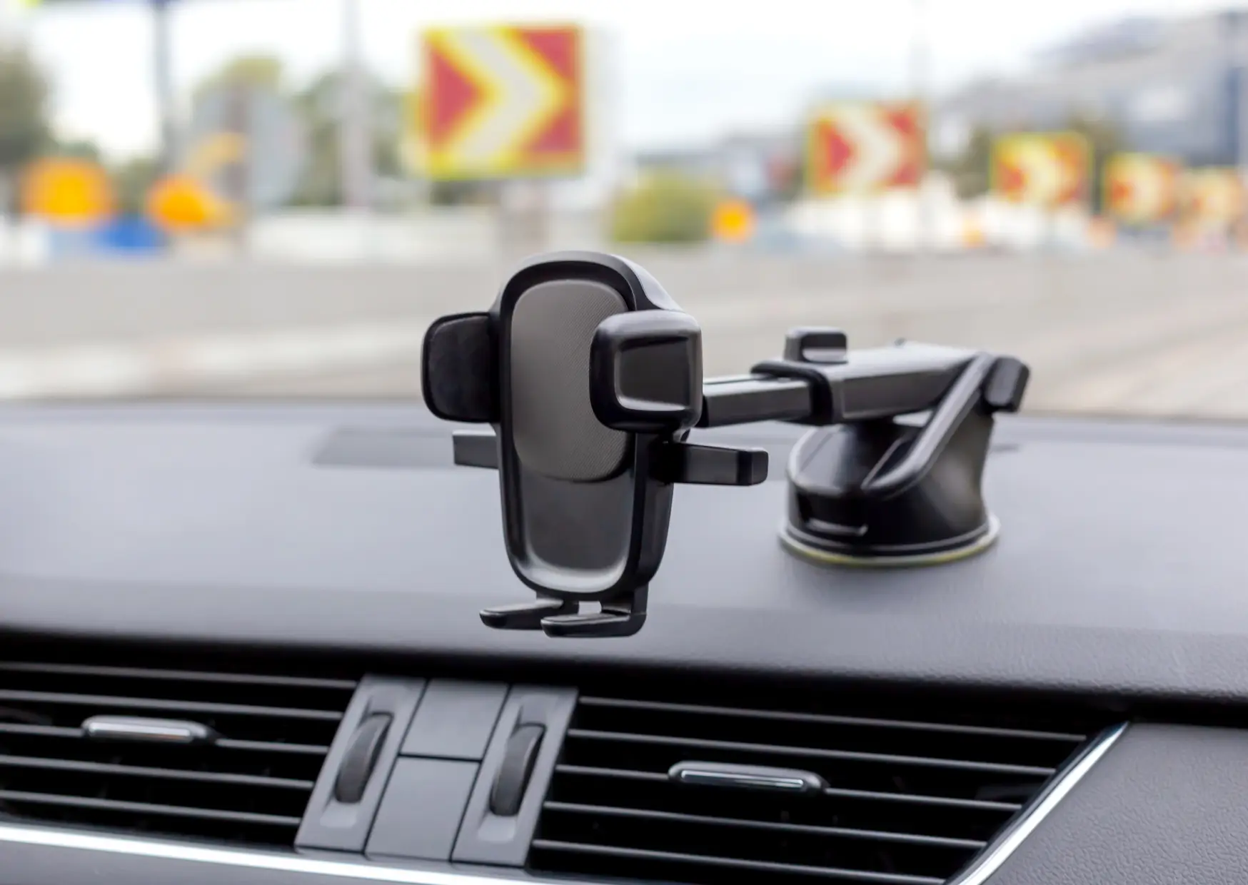 Phone holder mounted on a car dashboard, holding a smartphone for easy visibility while driving.