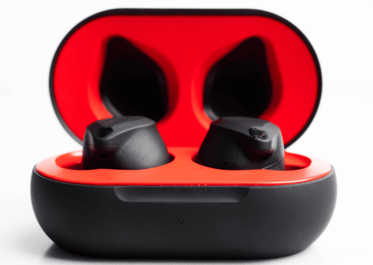 Close-up of earbuds with a black exterior and red interior, displayed against a white background, featuring an open earbud case showing the earbuds inside.