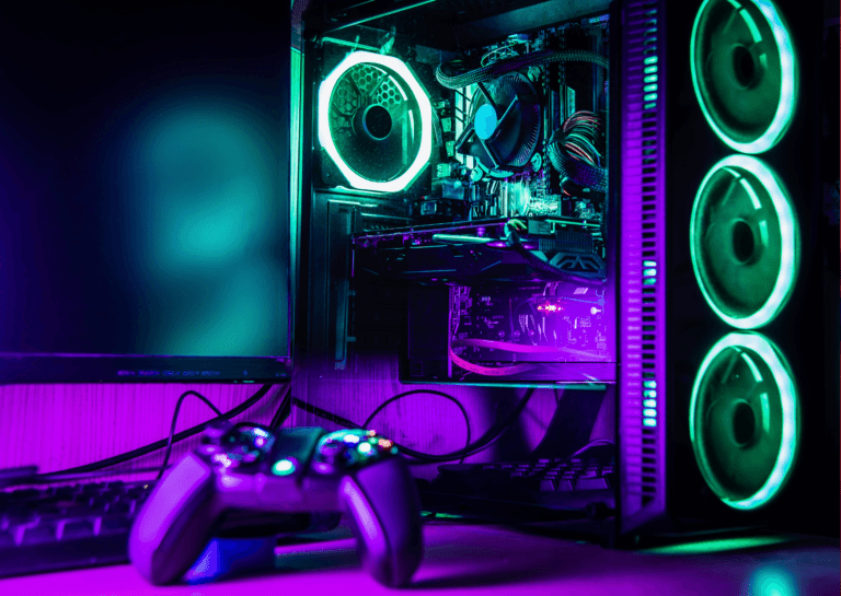 Close-up of a gaming PC showcasing the monitor and keyboard, with the desktop prominently displaying its internal components, illuminated in purple and green lights.