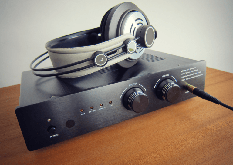 Headphone amplifier placed on an antique brown desk, with materials that reflect a vintage style.