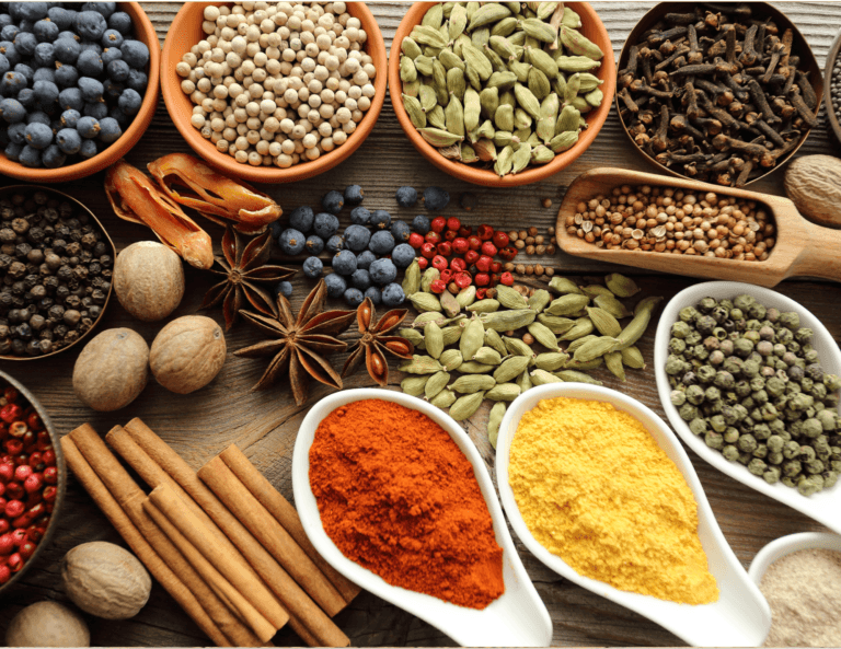 Colorful assortment of imported spices and seasonings, featuring blueberries, walnuts, and cinnamon in various containers on a wooden table, creating a vibrant and healthy food display.