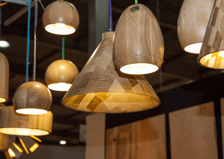 Cluster of illuminated pendant lights with a wood-look finish, hanging at various heights for a layered effect.