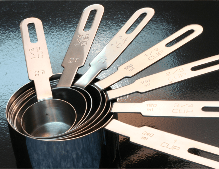 Stacked measuring cups and spoons of various sizes, designed to fit perfectly into each other for convenient storage.