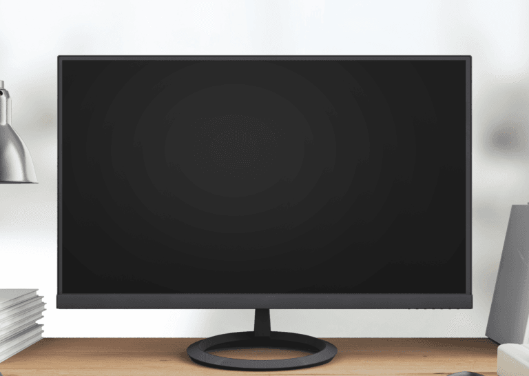 Black computer monitor turned off, positioned on a brown desk.