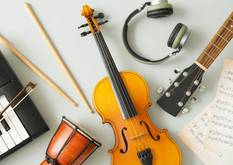 Musical instruments including a violin, guitar, drumsticks, old headphones, keyboard, violin string, sheet music, and a drum on a white background.