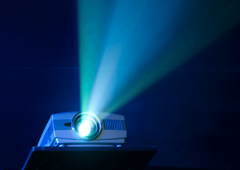 Projectors projecting bright light beams at an angle, creating a cinematic atmosphere in dark rooms.