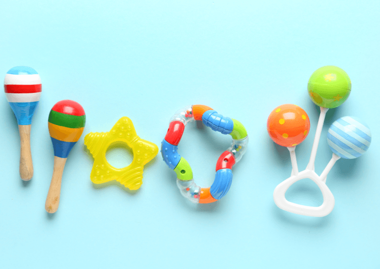 Five colorful rattles and shakers displayed on a light blue background, showcasing various shapes and designs for infants.