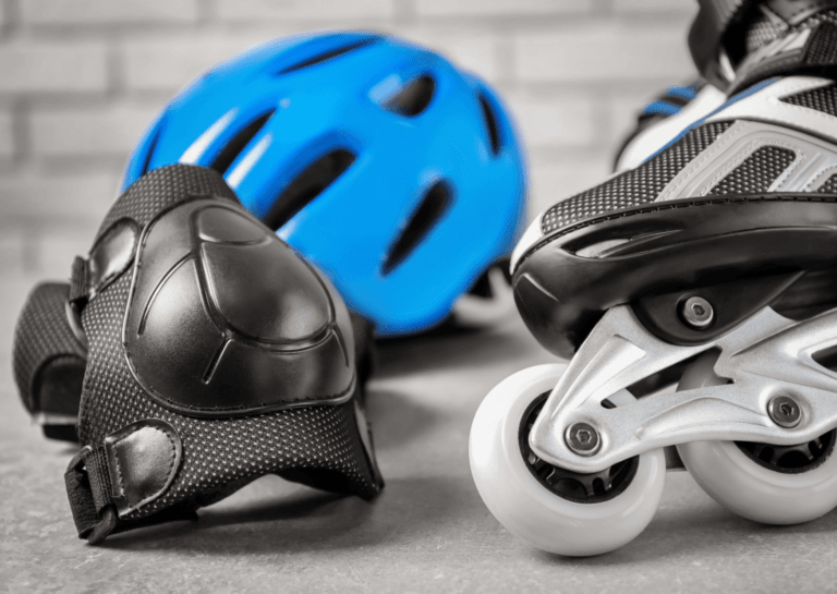 The front view of an inline skate with a knee pad and a blue skate helmet, set against a white background.