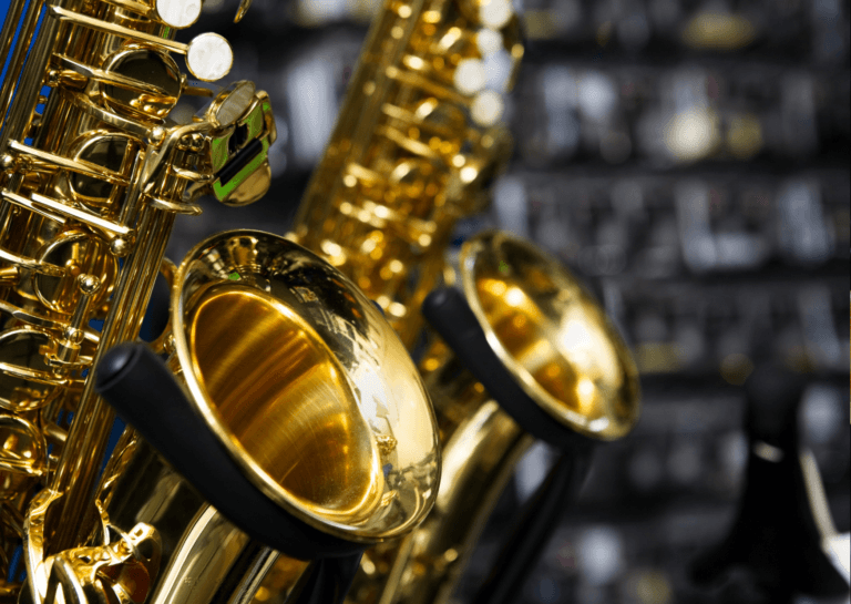 Close-up of two gold saxophone musical instruments, showcasing their shiny finish and intricate details.