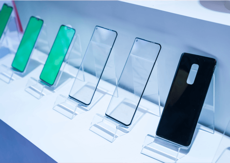 Clear, black, and transparent green screen protectors of various sizes displayed upright in a holder.