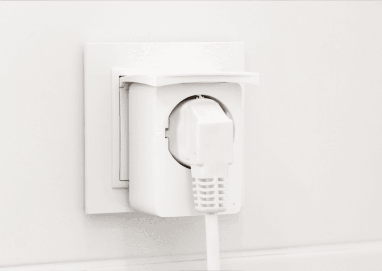 White smart plug outlet in a socket against an all-white background, emphasizing its sleek design.