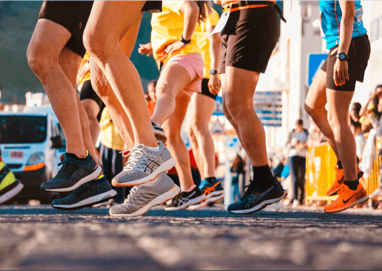 A close-up image capturing only the legs of a person wearing sporty leggings and athletic shoes, with one leg lifted off the ground, creating the impression of movement and active exercise. The focus highlights a dynamic and energetic workout vibe.