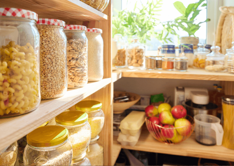 Organized kitchen storage with neatly arranged food in labeled storage jars on shelves.