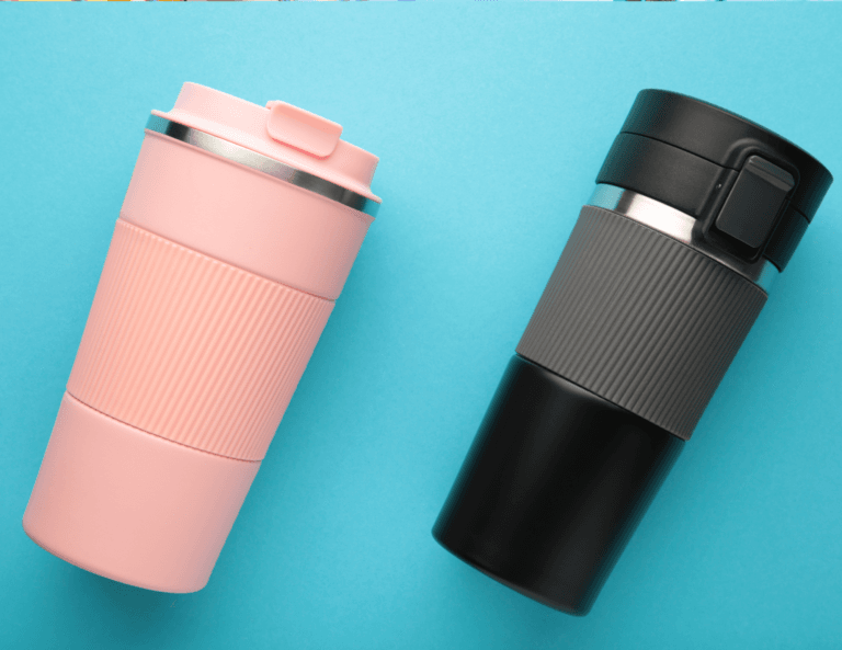 Two travel mugs, one pink and one black, positioned at an angle next to each other on a light blue background.