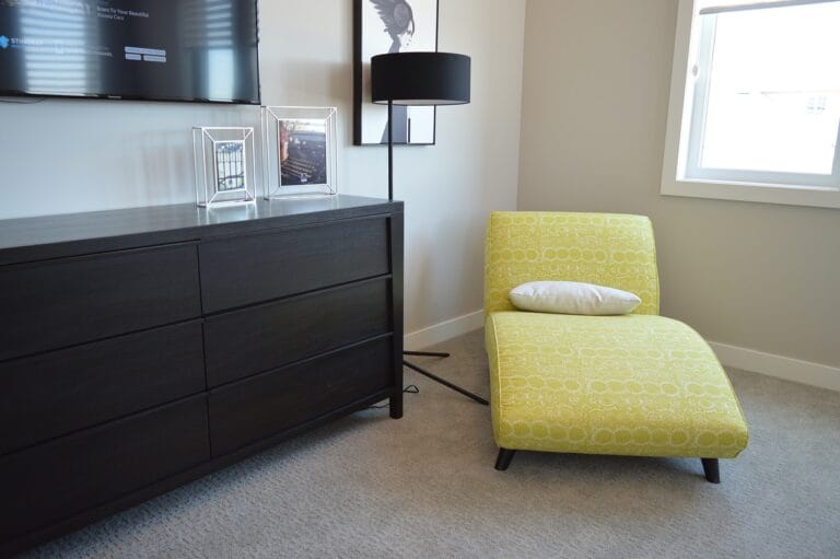 Yellow lounge chair positioned near a sideboard, adding a pop of color to the room.