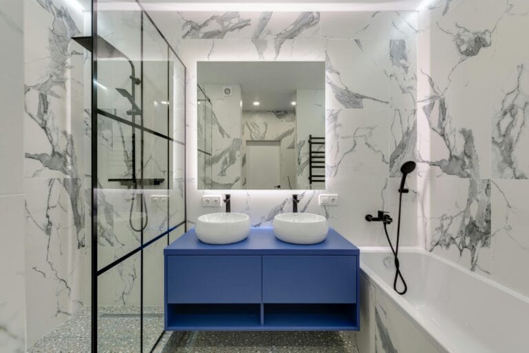 Modern bathroom featuring a shower and bathtub, complemented by two round sinks for a stylish and functional design