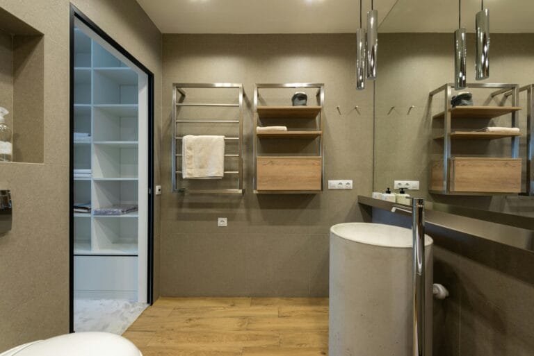 Interior of contemporary bathroom with towel hanging on rack under lights on ceiling with sink near mirror