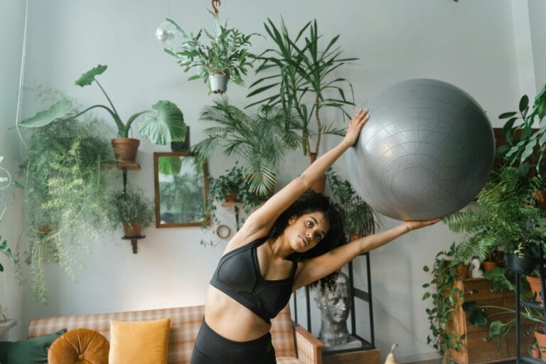 Woman in Black Activewear Holding a Yoga Ball