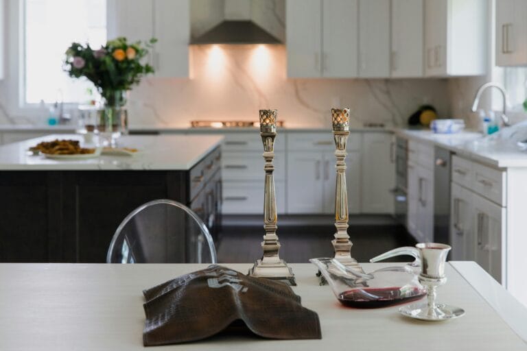 Two gold lanterns on a kitchen countertop, with the kitchen and island visible in the background.