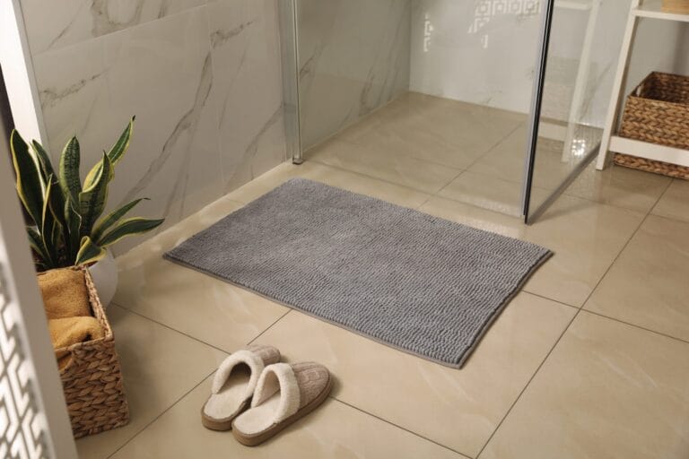 Luxurious bath mat placed in a pristine bathroom with elegant marble wall tiles and minimalist decor